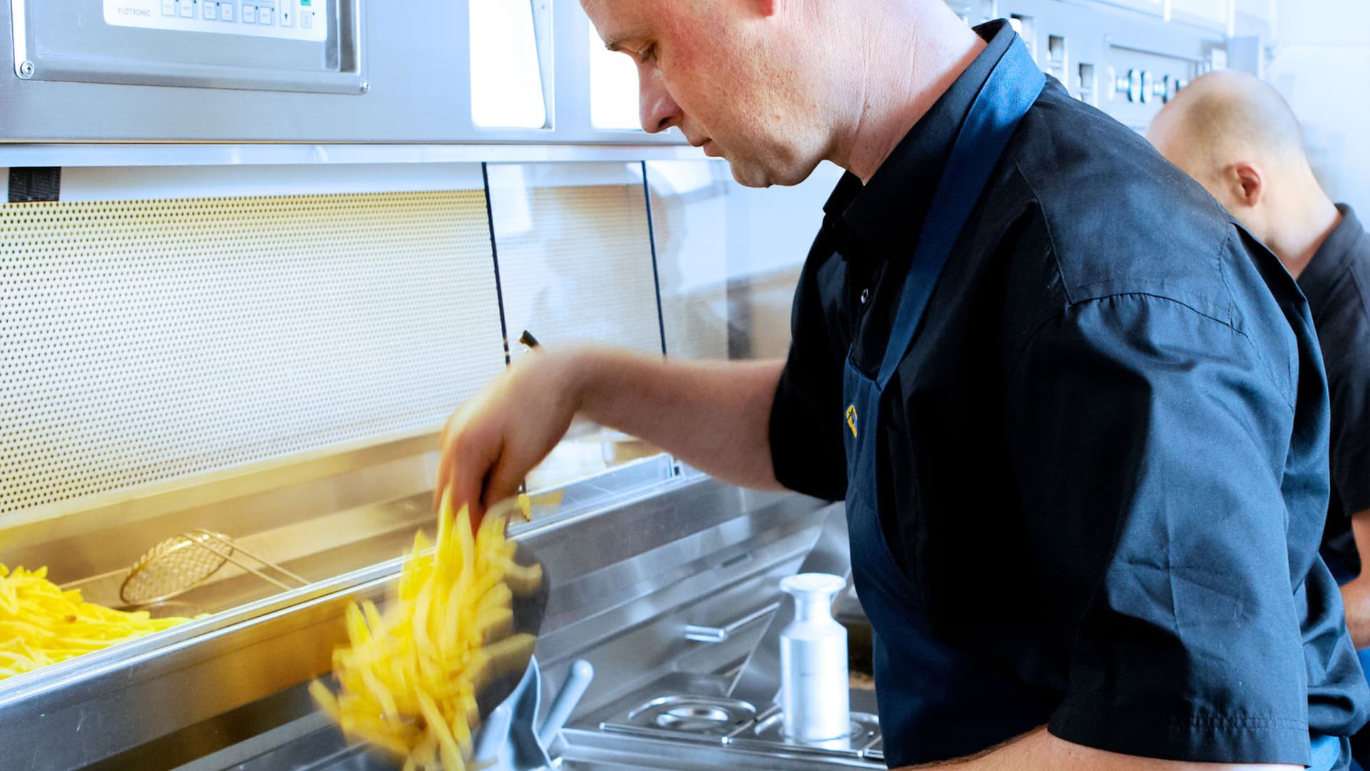 Man bakt friet in de keuken